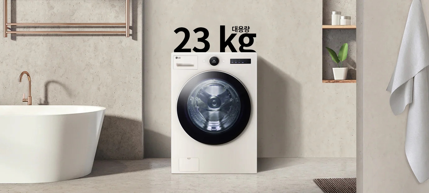 세탁기가 욕실에 놓여 있으며, 세탁기 위에는 "대용량 23 kg"이라는 문구가 있습니다. 욕조와 수건이 걸려 있고, 벽면 선반에는 화분과 용기가 놓여 있습니다.